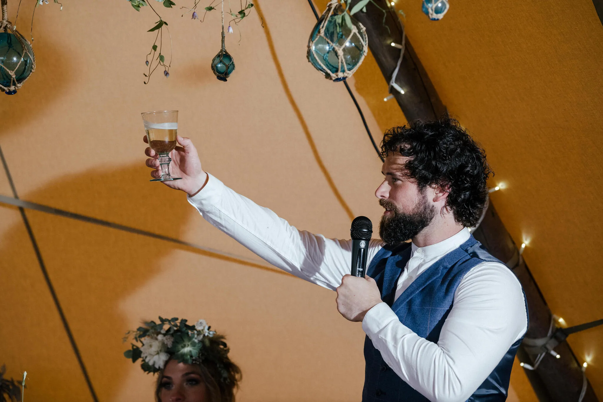 Guest raising a toast inside a tipi at a Yorkshire wedding